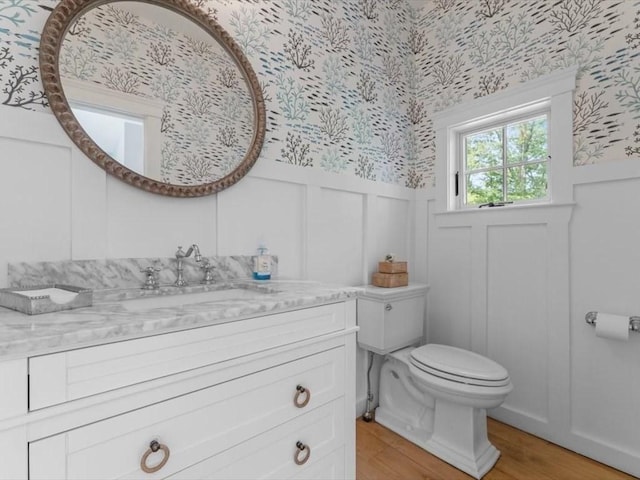 35 Forster Rd, Manchester, MA 01944 - bathroom featuring wallpapered walls, a decorative wall, wainscoting, vanity, and wood finished floors