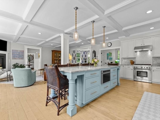 35 Forster Rd, Manchester, MA 01944 - kitchen with appliances with stainless steel finishes, coffered ceiling, open floor plan, under cabinet range hood, and light wood finished floors