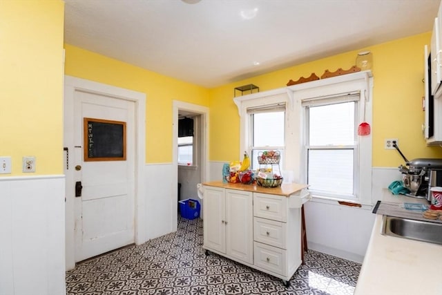 57 Ardale St, Boston, MA 02131 - kitchen featuring wainscoting, healthy amount of natural light, white cabinetry, light flooring, and light countertops