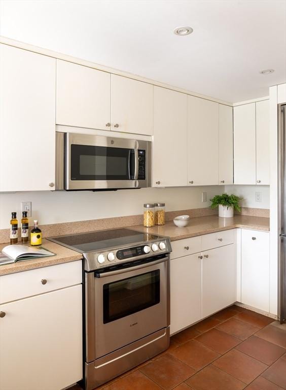 kitchen with recessed lighting, appliances with stainless steel finishes, white cabinets, and light countertops