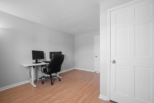 office featuring baseboards and light wood finished floors