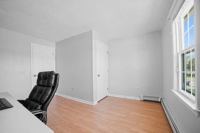 office featuring light wood-style floors, baseboards, and baseboard heating