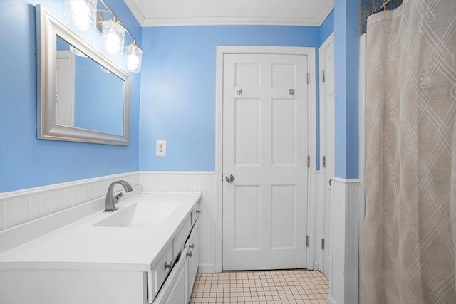 full bath with a wainscoted wall, ornamental molding, vanity, and tile patterned floors