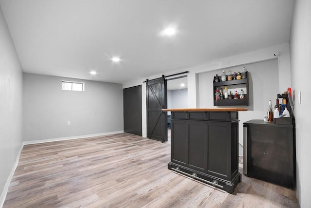 bar with a barn door, baseboards, a bar, light wood-style floors, and recessed lighting