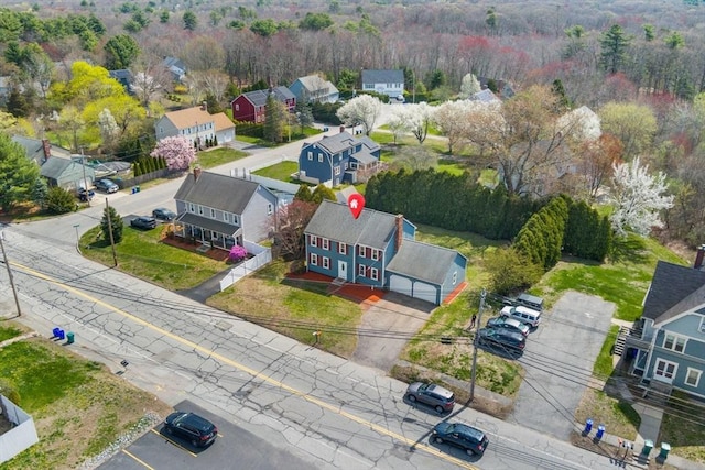 birds eye view of property featuring a wooded view and a residential view
