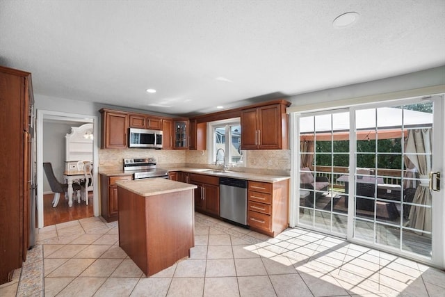 kitchen with light countertops, a sink, backsplash, and stainless steel appliances