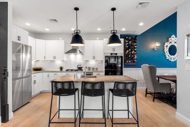 kitchen featuring visible vents, light wood-style flooring, and appliances with stainless steel finishes