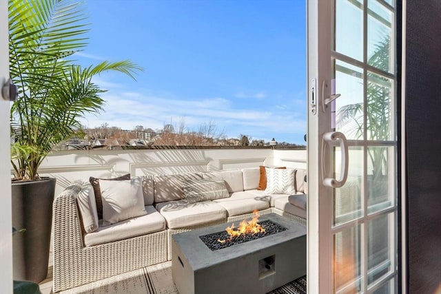 balcony featuring an outdoor living space with a fire pit