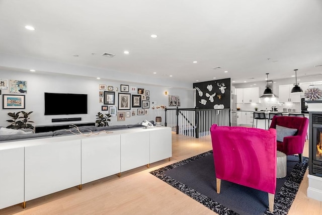 living room featuring recessed lighting, visible vents, and light wood-style flooring