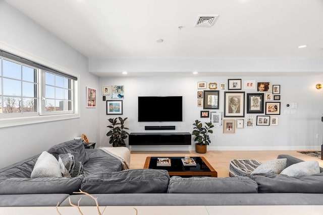 living room featuring recessed lighting, visible vents, baseboards, and wood finished floors