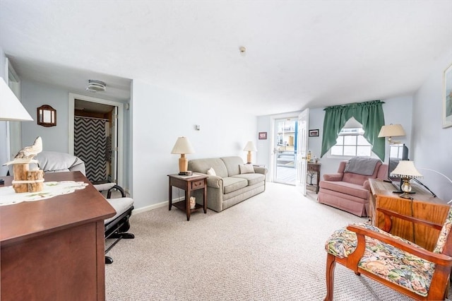 living area with baseboards and light colored carpet