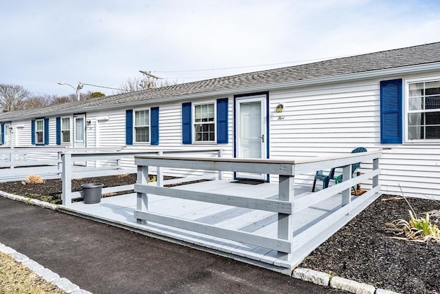 view of front of home featuring a shingled roof and a deck