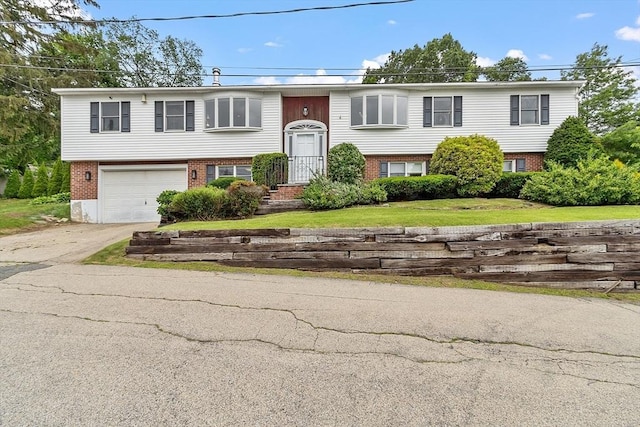 82 Powow St, Amesbury, MA 01913 - raised ranch with brick siding, driveway, a garage, and a front lawn