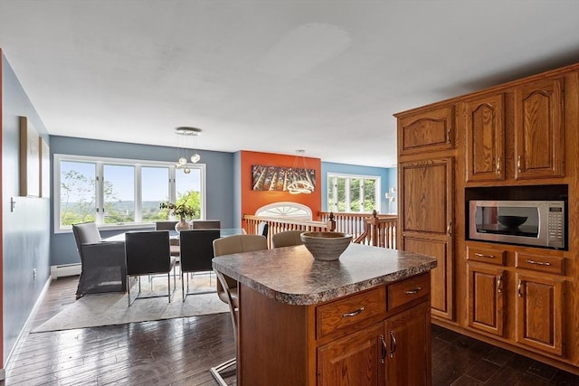 82 Powow St, Amesbury, MA 01913 - kitchen with stainless steel microwave, baseboard heating, dark wood-type flooring, and dark countertops