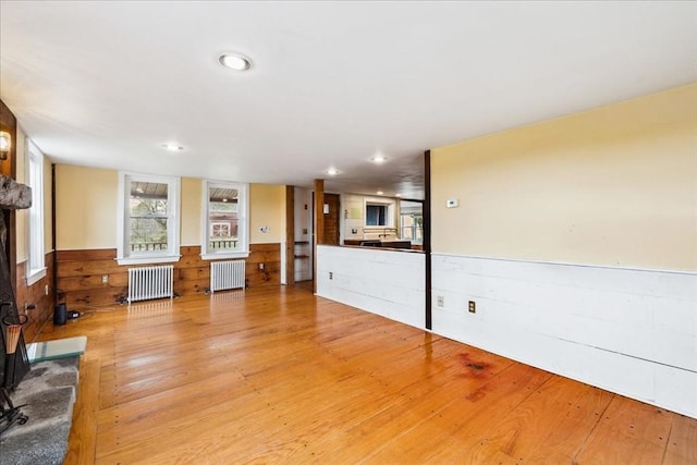 unfurnished living room with radiator heating unit and light wood-style flooring