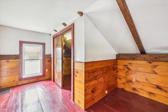 additional living space featuring wood-type flooring, a wainscoted wall, and wooden walls