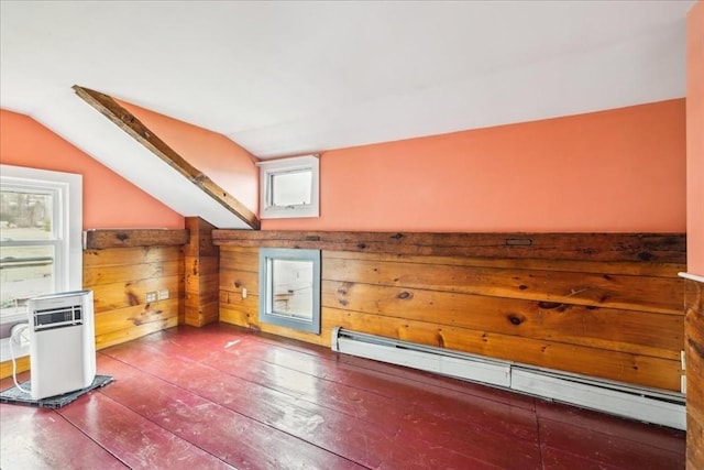 additional living space featuring lofted ceiling, a baseboard heating unit, a wealth of natural light, and hardwood / wood-style flooring