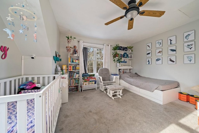 bedroom with a crib, carpet floors, ceiling fan, and lofted ceiling