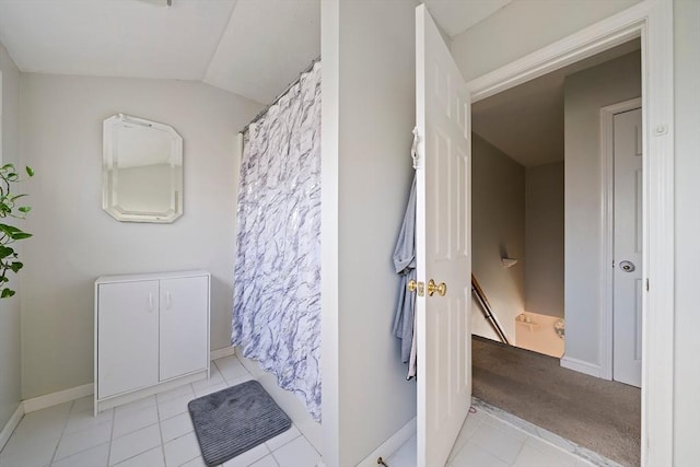 bathroom featuring tile patterned flooring and vaulted ceiling