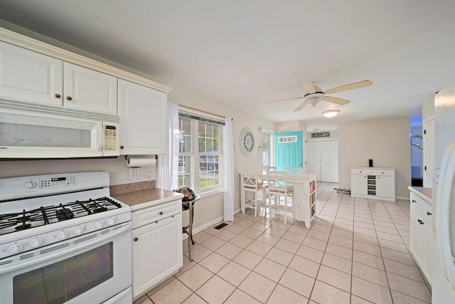 kitchen with white appliances, white cabinetry, ceiling fan, and light tile patterned flooring