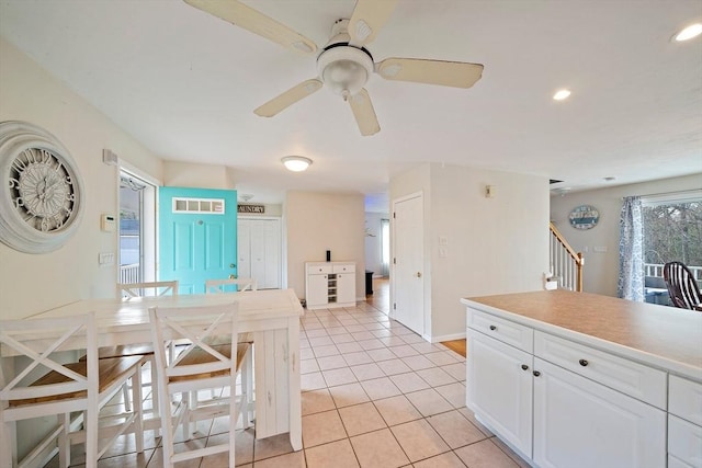 kitchen featuring ceiling fan, white cabinets, and light tile patterned floors