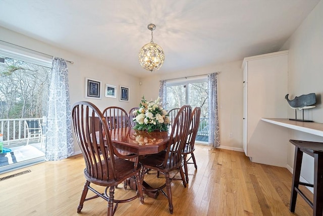 dining area featuring light hardwood / wood-style floors and an inviting chandelier