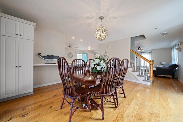 dining area featuring ceiling fan with notable chandelier and light hardwood / wood-style floors