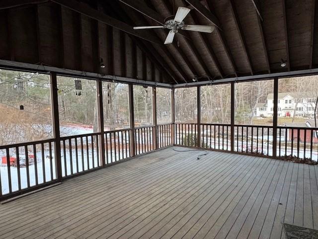 unfurnished sunroom with vaulted ceiling and ceiling fan