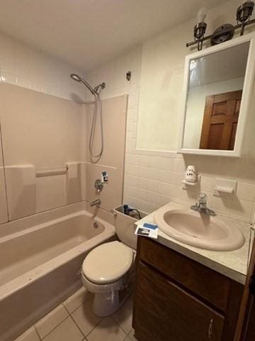 full bathroom with tile patterned floors, toilet, tile walls, shower / washtub combination, and vanity