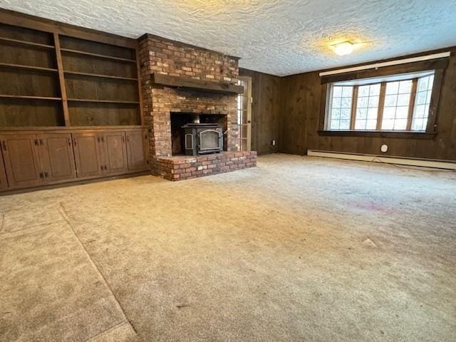 unfurnished living room with a baseboard radiator, wooden walls, light carpet, and a textured ceiling