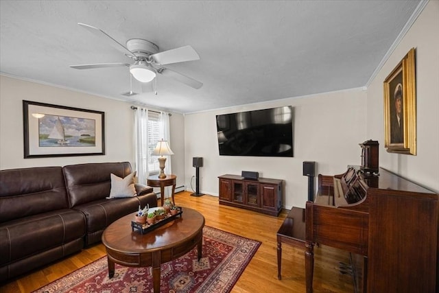 living area featuring wood finished floors, a ceiling fan, and ornamental molding