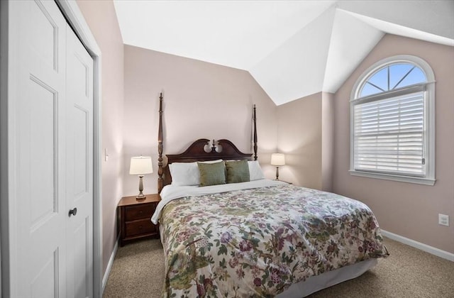 carpeted bedroom featuring a closet, baseboards, and vaulted ceiling