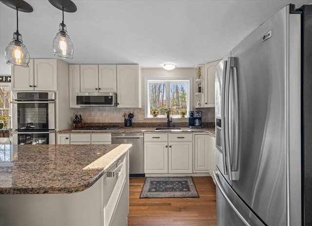 kitchen featuring stainless steel appliances, dark wood-style floors, decorative backsplash, and white cabinets