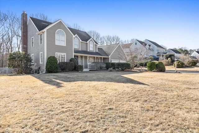 view of front of home featuring a porch, a chimney, a front yard, and fence