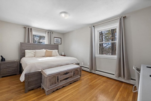 bedroom featuring baseboard heating and light wood finished floors