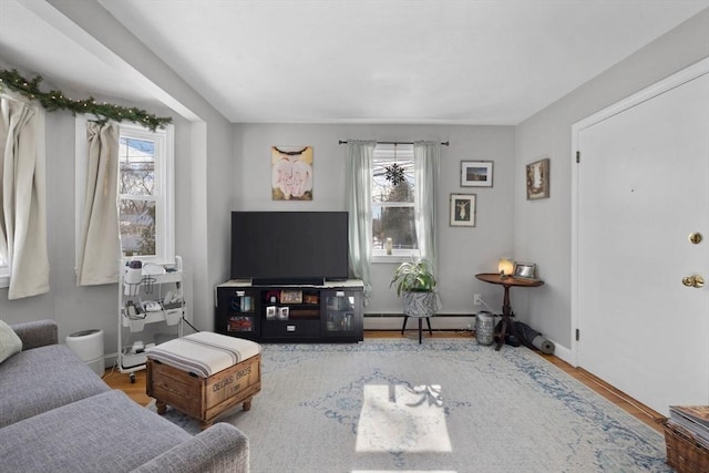 living room featuring baseboards, a baseboard heating unit, and wood finished floors