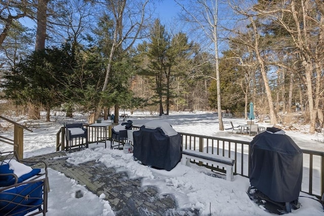 snow covered deck with a grill