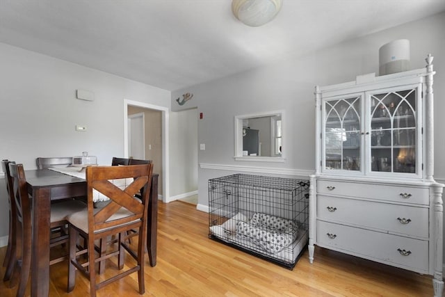 dining area featuring light wood-style flooring and baseboards