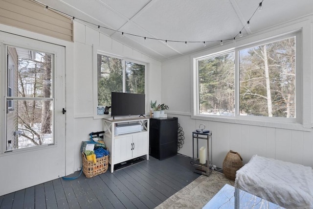 interior space with lofted ceiling, multiple windows, and dark wood finished floors