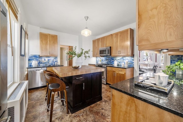 1 Murdock Ter, Boston, MA 02135 - kitchen featuring appliances with stainless steel finishes, backsplash, a kitchen island, and healthy amount of natural light