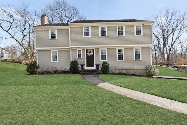 view of front of property with a chimney and a front lawn