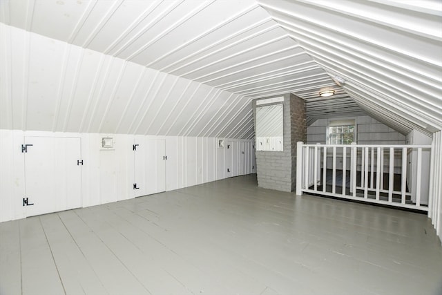 additional living space with vaulted ceiling and wood-type flooring