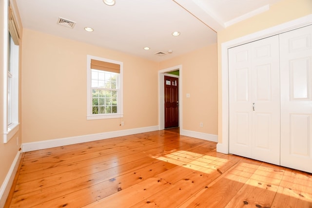 unfurnished bedroom featuring light hardwood / wood-style flooring and a closet