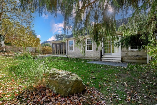 back of house featuring a yard and a sunroom