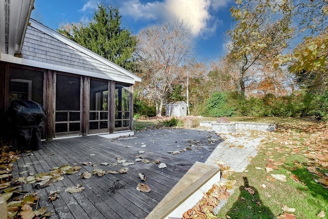 deck featuring a shed, a sunroom, and grilling area