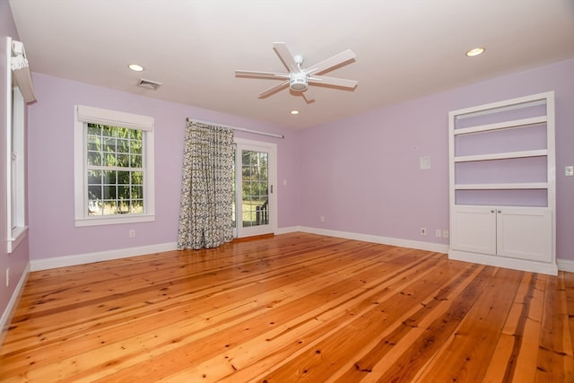 unfurnished room featuring built in features, light hardwood / wood-style floors, and ceiling fan