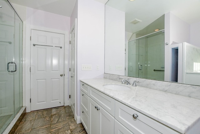 bathroom with vanity and a shower with shower door