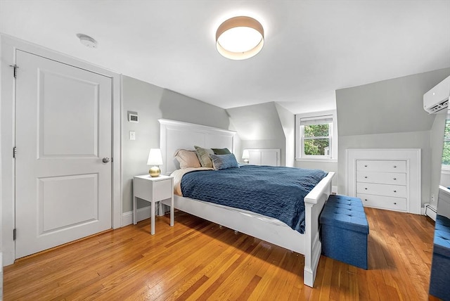 72 Marlboro St, Dedham, MA 02026 - bedroom with light wood finished floors, a wall mounted AC, and a baseboard heating unit