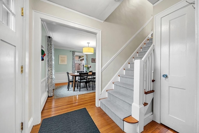 72 Marlboro St, Dedham, MA 02026 - foyer entrance with crown molding, light wood-type flooring, stairway, and a wainscoted wall
