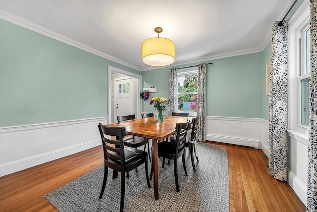 72 Marlboro St, Dedham, MA 02026 - dining space featuring baseboard heating, wood finished floors, crown molding, and a wainscoted wall